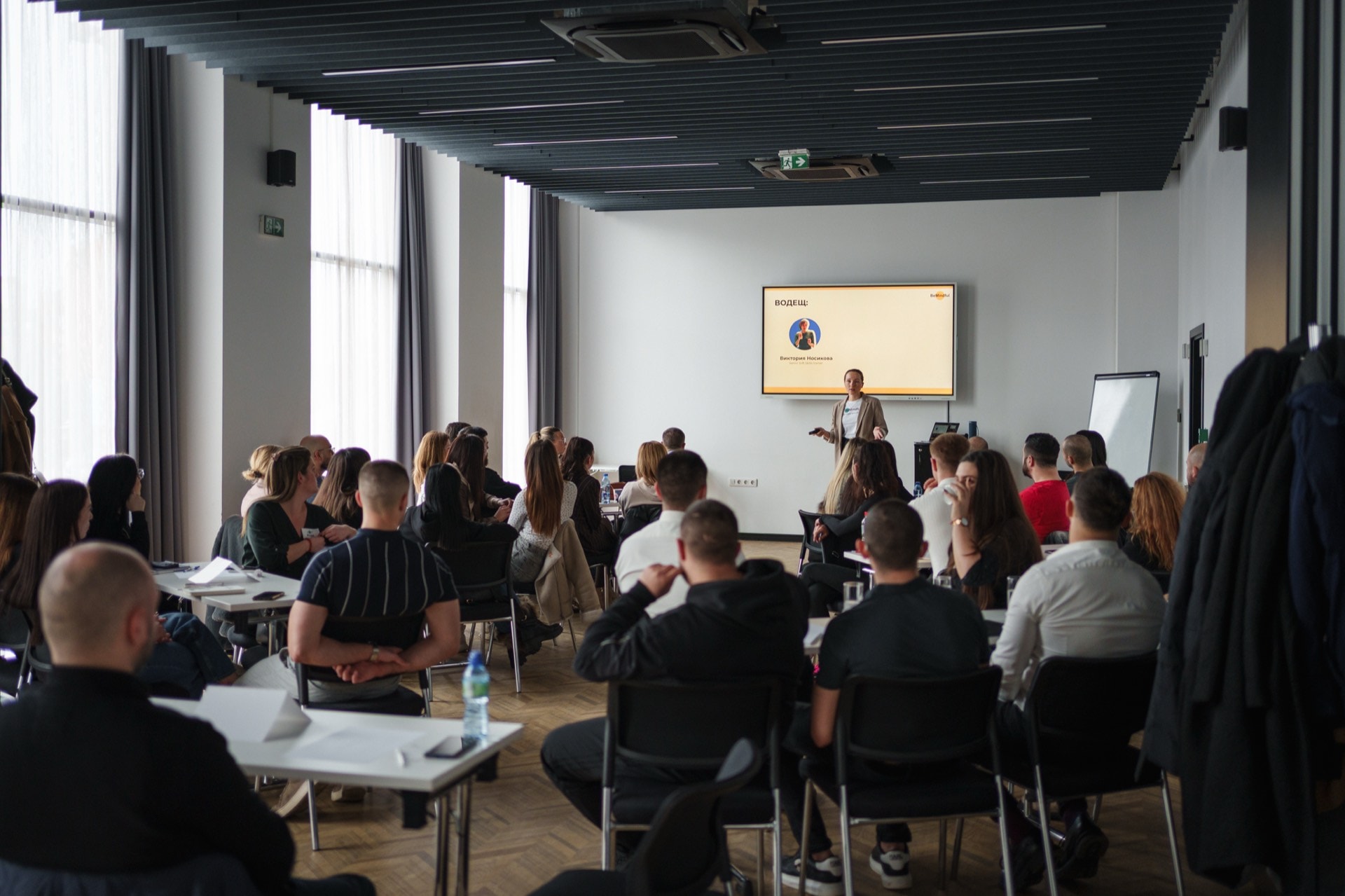 A full room during a training session, the facilitator presenting at the screen