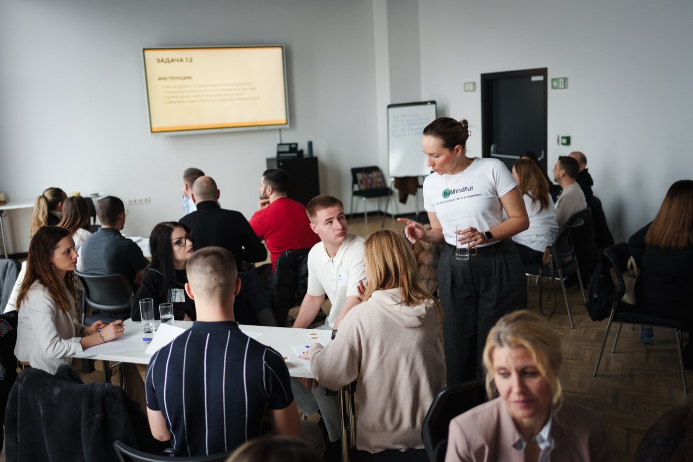 A facilitator explaining the task to a group of participants around a table